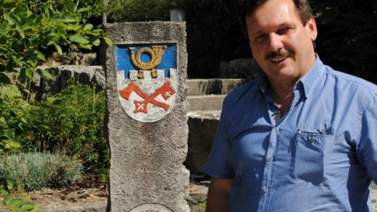 Bürgermeister Paul Reithmeir weist im Gemeindegarten auf einen Stein mit dem Eurasburger Wappen hin. Fotos: Christine Hornischer